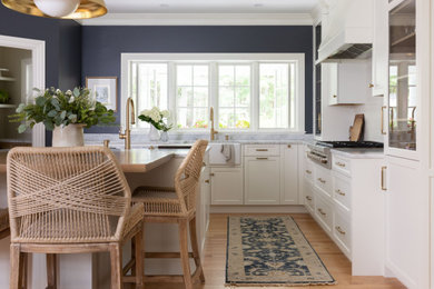 ポートランド(メイン)にある高級な中くらいなトラディショナルスタイルのおしゃれなキッチン (エプロンフロントシンク、フラットパネル扉のキャビネット、白いキャビネット、大理石カウンター、白いキッチンパネル、セラミックタイルのキッチンパネル、シルバーの調理設備、淡色無垢フローリング、青いキッチンカウンター) の写真