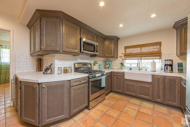 Enclosed kitchen - mid-sized traditional u-shaped terra-cotta tile and orange floor enclosed kitchen idea in Los Angeles with a farmhouse sink, gray cabinets, marble countertops, white backsplash, subway tile backsplash, stainless steel appliances, no island and recessed-panel cabinets