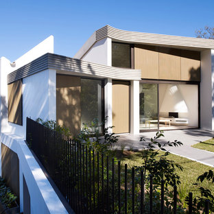 Photo of a modern white house exterior in Sydney with three or more storeys, mixed siding and a flat roof.