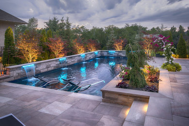 Mid-sized trendy backyard stone and rectangular pool photo in Toronto