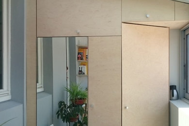 Cette image montre un petit placard dressing nordique en bois clair neutre.
