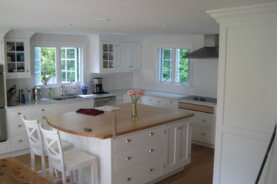 Eat-in kitchen - transitional l-shaped medium tone wood floor and brown floor eat-in kitchen idea in Bridgeport with an undermount sink, shaker cabinets, white cabinets, wood countertops, white backsplash, subway tile backsplash, stainless steel appliances and an island