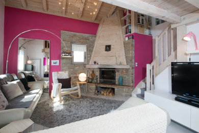 Aménagement d'un salon blanc et bois montagne de taille moyenne et ouvert avec une bibliothèque ou un coin lecture, un mur rose, un sol en carrelage de céramique, une cheminée d'angle, un manteau de cheminée en bois, un téléviseur indépendant, un sol gris, un mur en pierre, un plafond cathédrale et poutres apparentes.