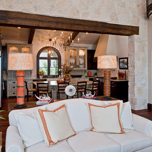 Geräumiges, Repräsentatives, Offenes Mediterranes Wohnzimmer mit weißer Wandfarbe, braunem Holzboden, Kamin und Kaminsims aus Stein in Austin