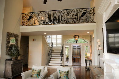 Example of a large beach style formal and open concept medium tone wood floor living room design in Charleston with white walls, a two-sided fireplace, a wood fireplace surround and a wall-mounted tv