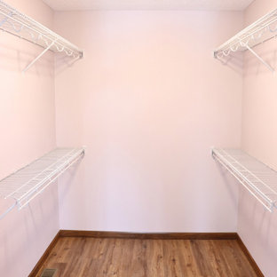 Foto di armadi e cabine armadio chic con ante con bugna sagomata, ante in legno scuro, pavimento in vinile, pavimento marrone e soffitto in perlinato