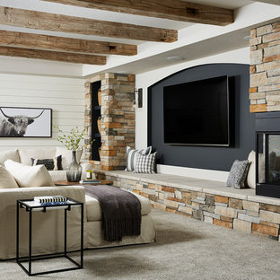 This is an example of a medium sized rural basement in Minneapolis with white walls, carpet, a corner fireplace, a stone fireplace surround and grey floors.