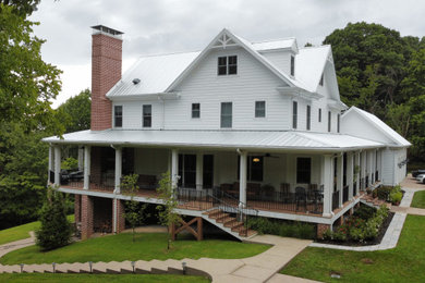 Modelo de fachada de casa blanca y blanca de estilo de casa de campo grande con tejado de metal