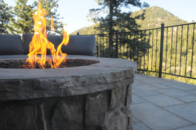 Inspiration for a rustic front yard stone patio remodel in Denver with a fire pit and no cover