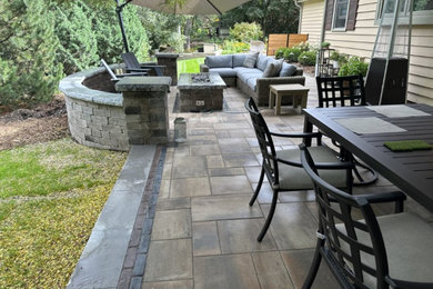 Ejemplo de patio actual de tamaño medio sin cubierta en patio trasero con cocina exterior y adoquines de piedra natural
