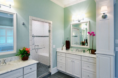 Inspiration for a mid-sized timeless master white tile and stone slab slate floor bathroom remodel in Orange County with recessed-panel cabinets, white cabinets, blue walls, marble countertops, an undermount sink and a hinged shower door