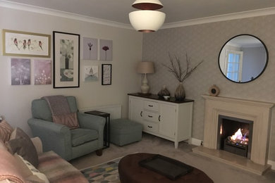 Design ideas for a mid-sized traditional living room in Surrey with beige walls, carpet, a stone fireplace surround and beige floor.
