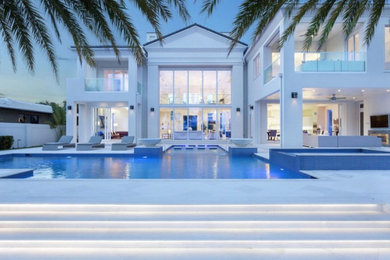 Example of a large trendy white two-story stucco house exterior design in Miami
