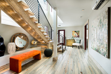 This is an example of a mid-sized contemporary foyer in Denver with white walls, light hardwood floors, a single front door and a red front door.