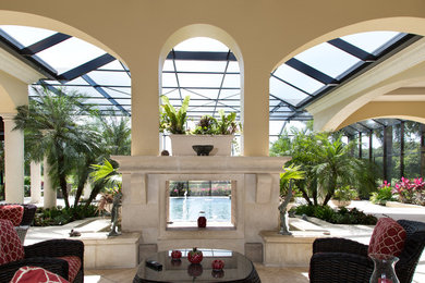 Mid-sized island style backyard stamped concrete patio photo in Miami with a fire pit