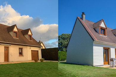 Idée de décoration pour une façade de maison beige tradition en panneau de béton fibré de taille moyenne et à un étage avec un toit en tuile.