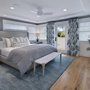 Mittelgroßes Maritimes Hauptschlafzimmer mit blauer Wandfarbe, hellem Holzboden, Kamin und gefliester Kaminumrandung in San Diego