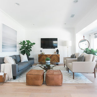 Inspiration for a large mid-century modern open concept light wood floor family room remodel in Orange County with white walls, no fireplace and a wall-mounted tv