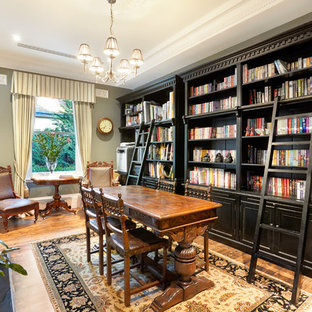 Mid-sized victorian enclosed family room in Melbourne with a library, grey walls, medium hardwood floors, a standard fireplace and brown floor.