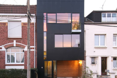 Exemple d'une grande façade de maison de ville noire moderne à trois étages et plus avec un revêtement mixte, un toit plat, un toit mixte et un toit gris.
