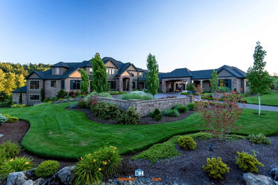 Example of a huge two-story stone gable roof design in Portland