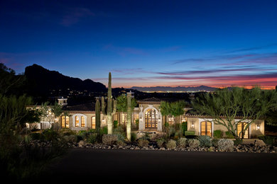 Large tuscan beige one-story stucco house exterior photo in Phoenix with a hip roof and a tile roof