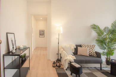 Imagen de salón cerrado minimalista de tamaño medio con paredes blancas, suelo laminado, suelo beige y alfombra