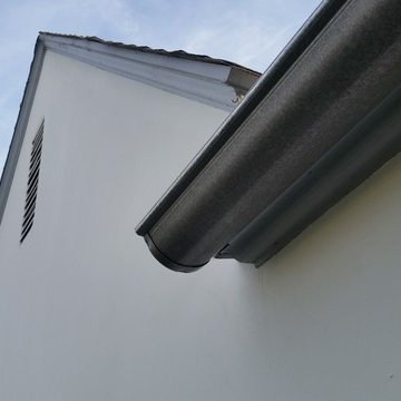 Bonderized Steel, 5 inch Half Round Seamless Gutters with Round Downspouts.