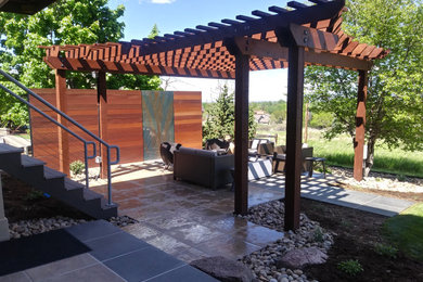 Inspiration for a mid-sized modern backyard patio in Denver with a fire feature, tile and a pergola.