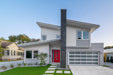 Example of a mid-sized trendy gray two-story concrete fiberboard house exterior design in Other with a shed roof and a metal roof