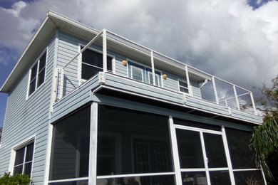 This is an example of a coastal cable railing back porch design in Tampa.