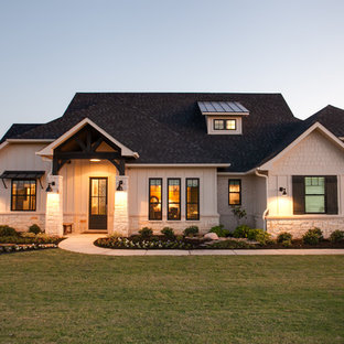 Создайте стильный интерьер: большой, одноэтажный фасад частного дома бежевого цвета в стиле кантри с комбинированной облицовкой, полувальмовой крышей и крышей из гибкой черепицы - последний тренд