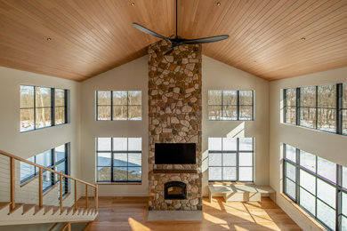 Living room - large transitional open concept light wood floor and shiplap ceiling living room idea in Detroit with white walls, a wood stove and a stone fireplace