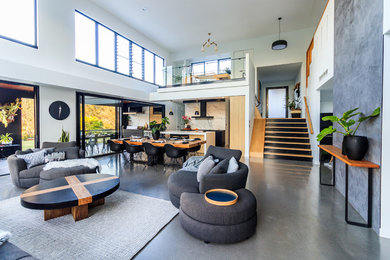 Large contemporary open concept living room in Sunshine Coast with concrete floors and grey floor.