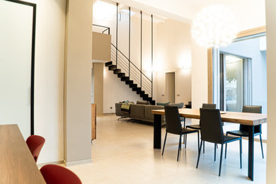 Foto di una grande sala da pranzo aperta verso la cucina contemporanea con pareti bianche, pavimento in gres porcellanato e pavimento beige