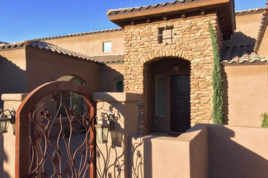 This is an example of a large mediterranean brown exterior in Phoenix with stone veneer and a hip roof.