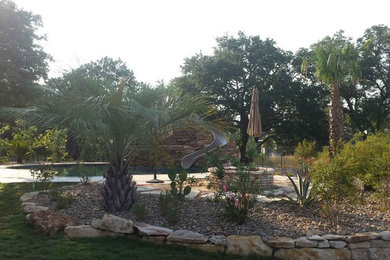 Large trendy backyard custom-shaped natural water slide photo in Austin with decking