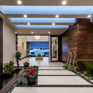 На фото: класса люкс огромные вестибюли в современном стиле с стеклянной входной дверью, бетонным полом и серым полом