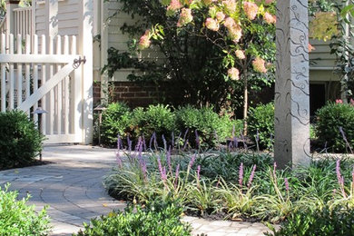 This is an example of a traditional backyard garden in Boston with a garden path and concrete pavers.