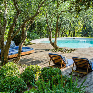 ボローニャの円形地中海スタイルのおしゃれな裏庭プール (デッキ材舗装) の写真