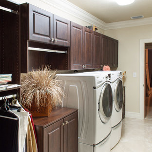 マイアミの中サイズのトラディショナルスタイルのおしゃれな家事室 (レイズドパネル扉のキャビネット、濃色木目調キャビネット、木材カウンター、ベージュの壁、大理石の床、左右配置の洗濯機・乾燥機) の写真