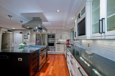 Eat-in kitchen - large contemporary l-shaped dark wood floor eat-in kitchen idea in San Francisco with a double-bowl sink, shaker cabinets, white cabinets, granite countertops, white backsplash, subway tile backsplash, stainless steel appliances and an island