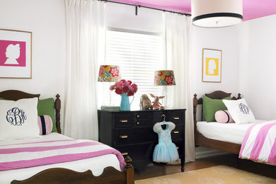 This is an example of a mid-sized eclectic kids' bedroom for kids 4-10 years old and girls in St Louis with white walls and medium hardwood floors.