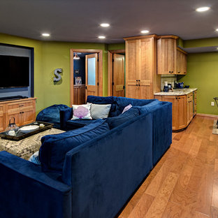 This is an example of a large traditional look-out basement in Minneapolis with green walls, medium hardwood flooring, no fireplace and brown floors.