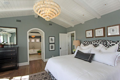 Elegant master medium tone wood floor bedroom photo in Austin with gray walls and no fireplace