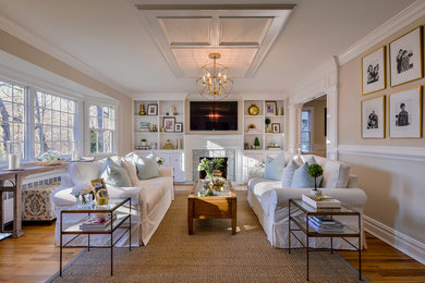 Example of a mid-sized transitional enclosed medium tone wood floor living room design in New York with a standard fireplace, a wall-mounted tv and beige walls