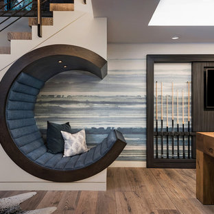 Foto de sótano actual, de tamaño medio, con suelo marrón, paredes multicolor y suelo de madera oscura