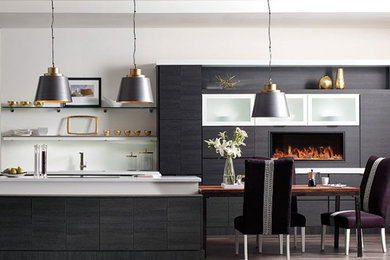 Example of a mid-sized single-wall dark wood floor and brown floor open concept kitchen design in Columbus with an undermount sink, flat-panel cabinets, black cabinets, quartz countertops, an island and white countertops
