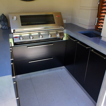 Outdoor Kitchen | polished concrete worktops, black cabinets and dark timber