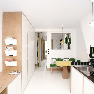 Cette photo montre une petite cuisine américaine parallèle tendance avec un placard à porte plane, une crédence noire et une crédence en carreau de céramique.